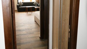 Un pasillo que conduce a una sala de estar con un sofá y una mesa.