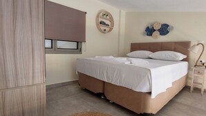 A bedroom with a bed, a bedside table, a lamp, a wall-mounted shelf with decorative items, and a large window with a blind. - Luxury New Loft Apartments in Halkidiki (Agios Mamas, Chalkidiki)