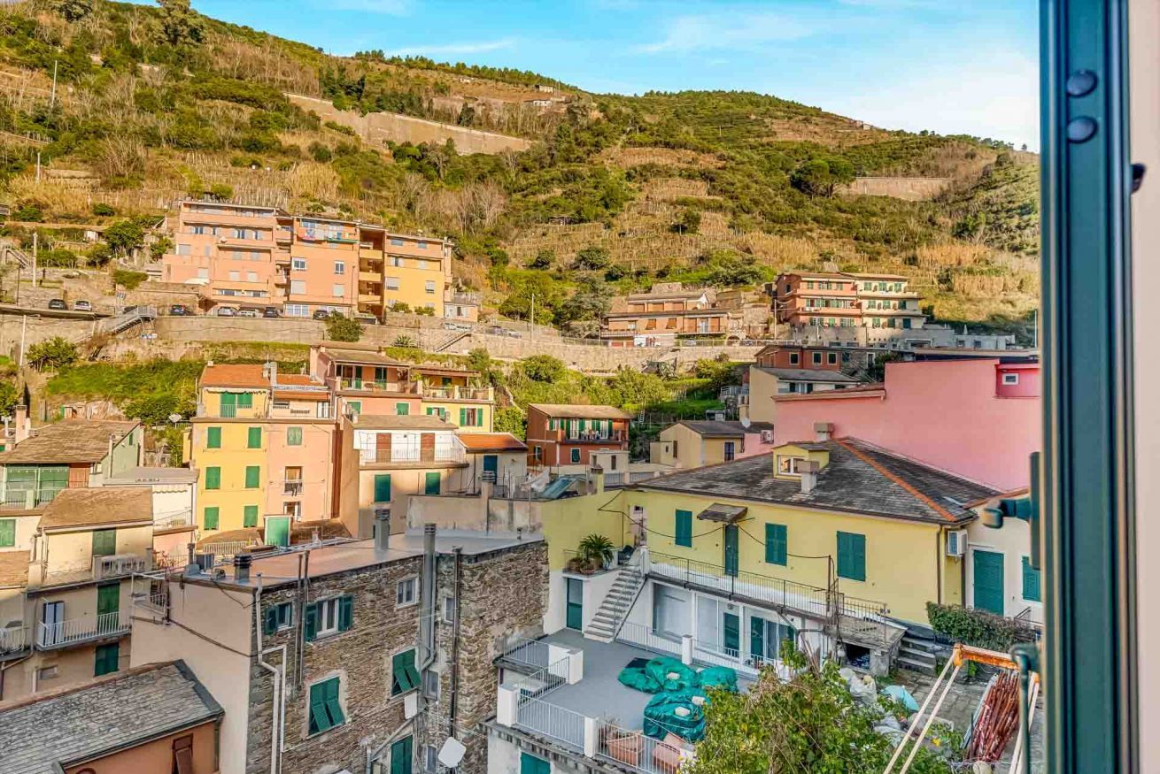 Un quartier résidentiel situé sur une colline, avec des bâtiments aux couleurs vives, un escalier bien visible et une vue dégagée sur le paysage environnant.