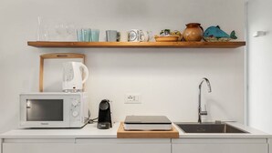 A kitchen with a microwave, kettle, coffee maker, and a sink. - GuestHost - Riomaggiore cozy studio x4! (Riomaggiore)