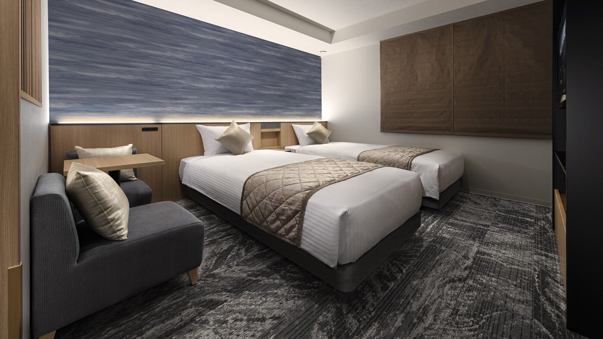 A hotel room with two beds, a sofa, a small table, and a large window.