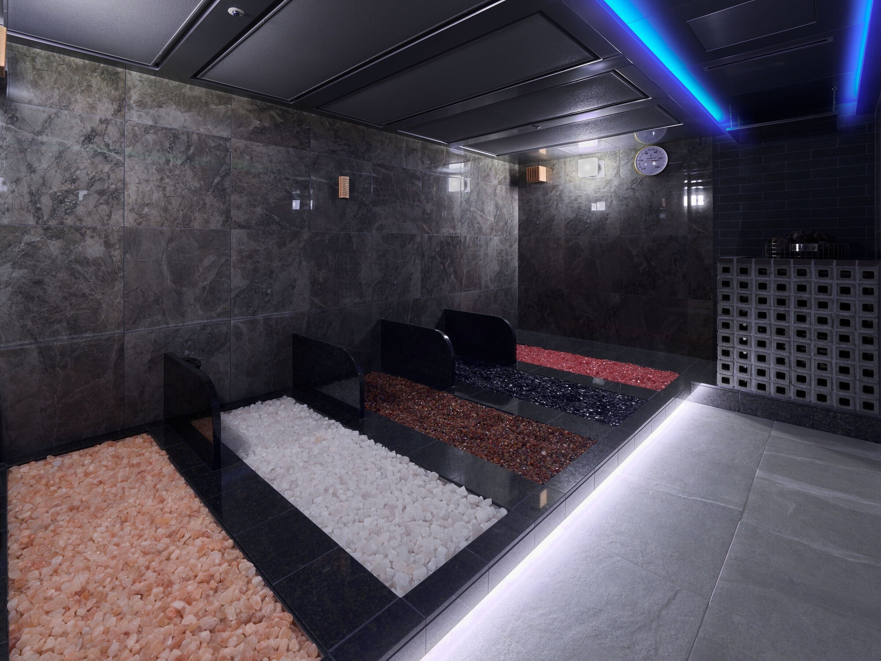 A spa area with multiple seating areas, each with a different type of pebble flooring.