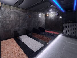 A spa area with multiple seating areas, each with a different type of pebble flooring.