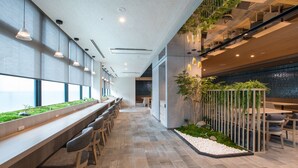 Een modern interieur met een lange balie, een zithoek en uitzicht op het omliggende landschap.