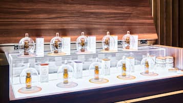 A display of various scented products in glass domes, each labeled with a scent name and price.