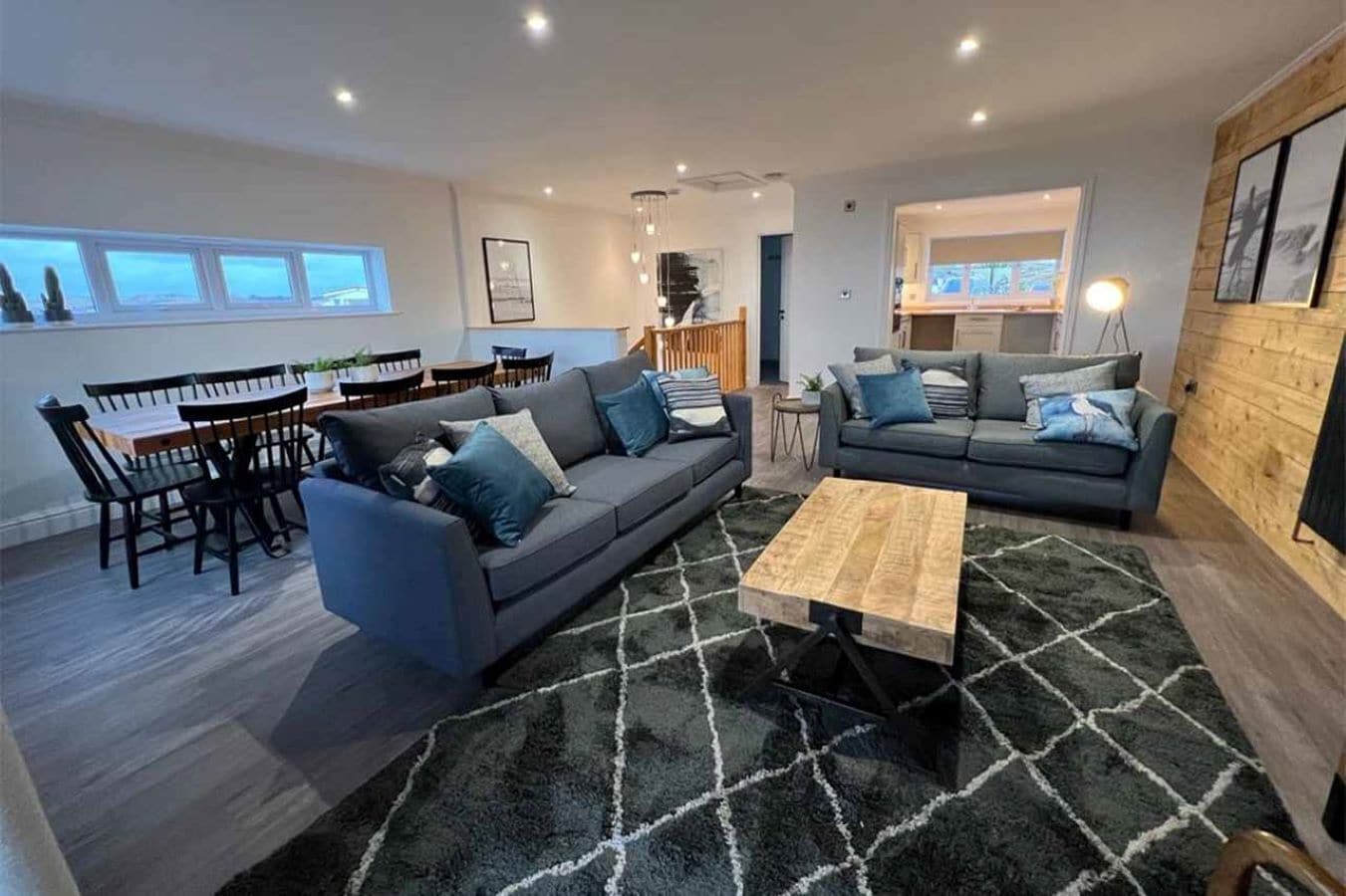 A modern living room with two sofas, a dining table, and chairs.