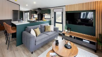 Un espacio de sala moderno con sofá, mesa de centro y televisor.
