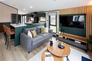 A modern living area with a sofa, coffee table, and a TV.