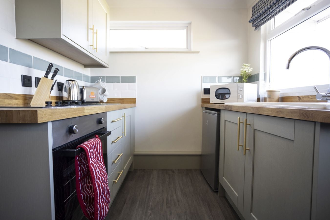 A compact kitchen with a built-in oven, a microwave, and a dishwasher.