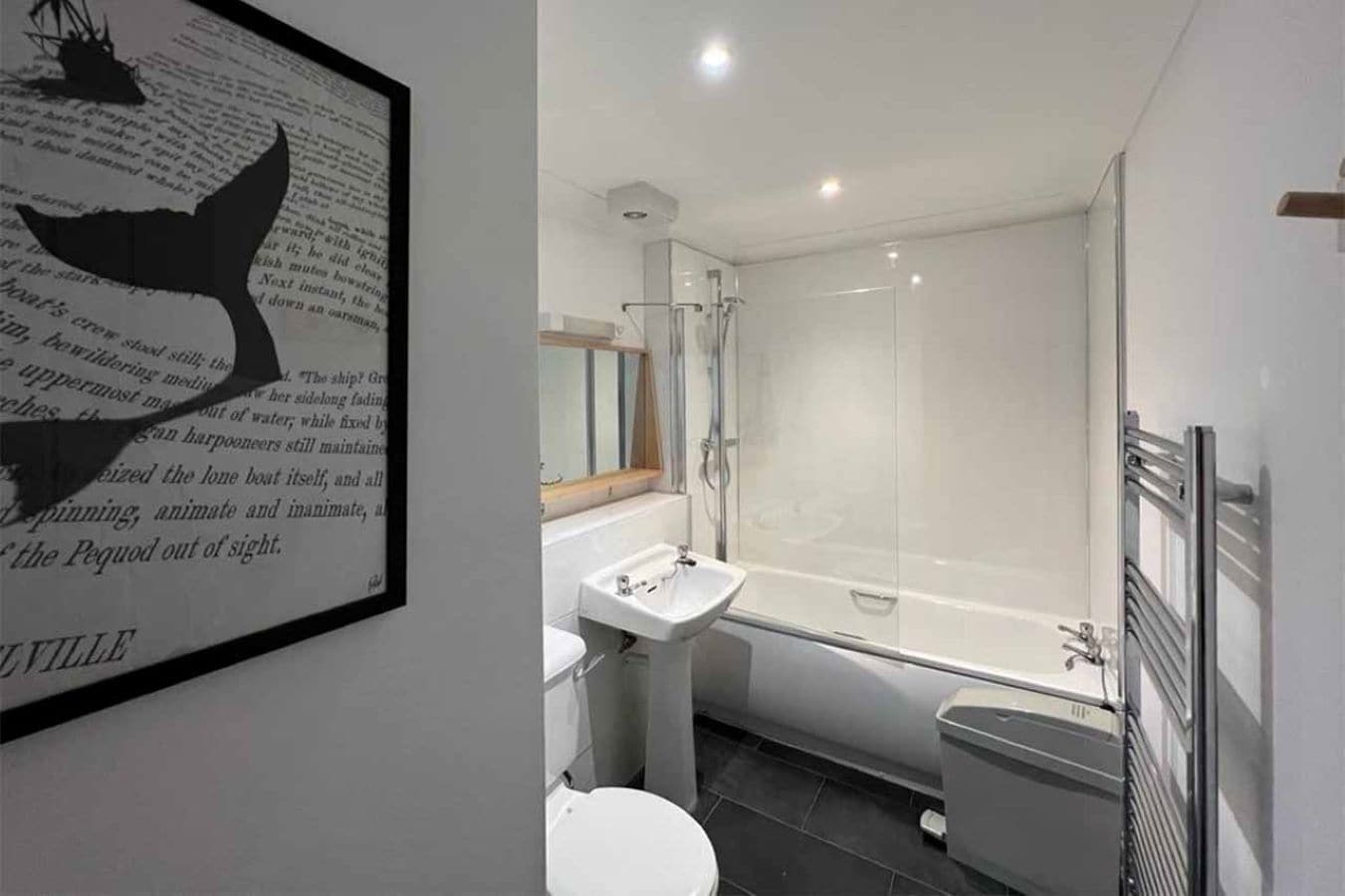 A modern bathroom with a bathtub, a sink, and a toilet.