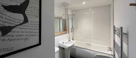 Un baño moderno con bañera, lavamanos e inodoro.