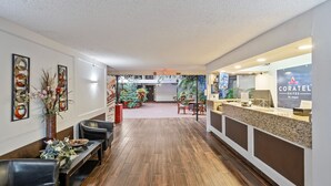 Un hall d’hôtel comprenant un comptoir d’accueil, un espace salon et un sapin de Noël.