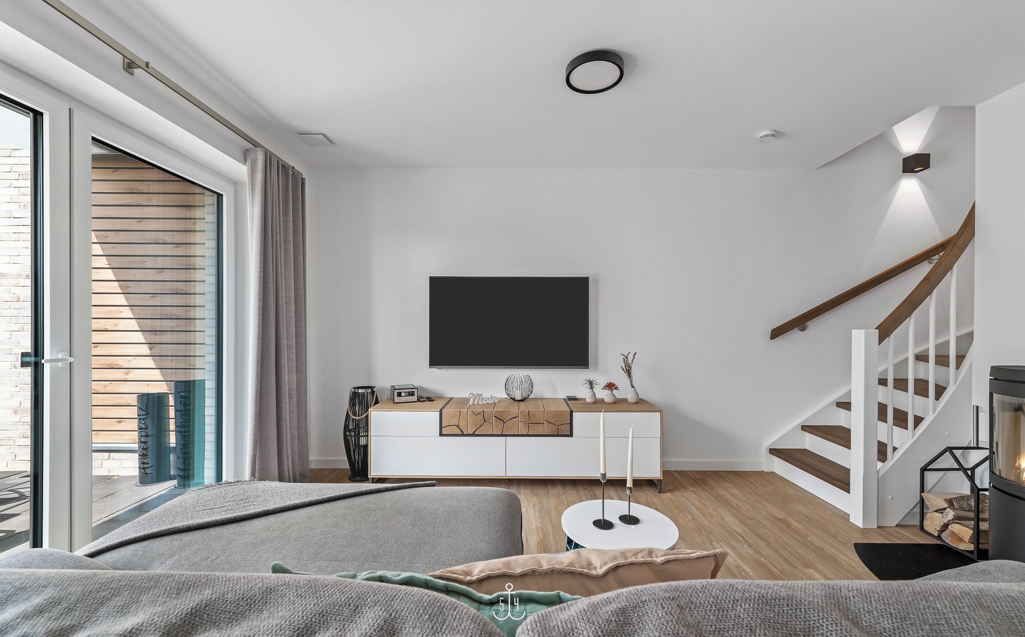 Un salon moderne avec un canapé, une table basse, une cheminée et un escalier.