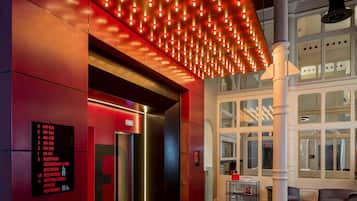 A modern lobby with a red and black color scheme, a digital directory sign, and a large column.