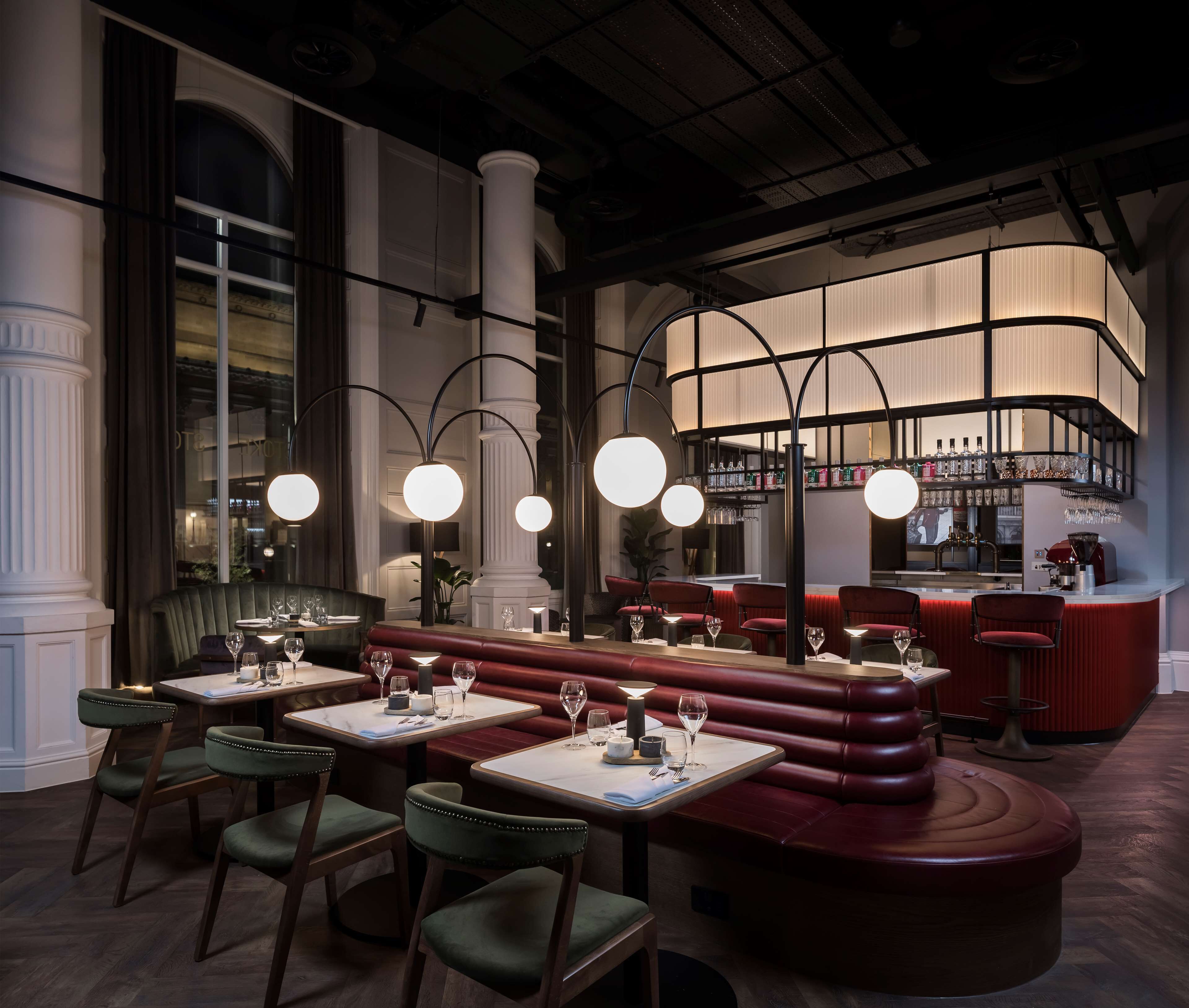 A restaurant with a bar area, booths, and a counter.