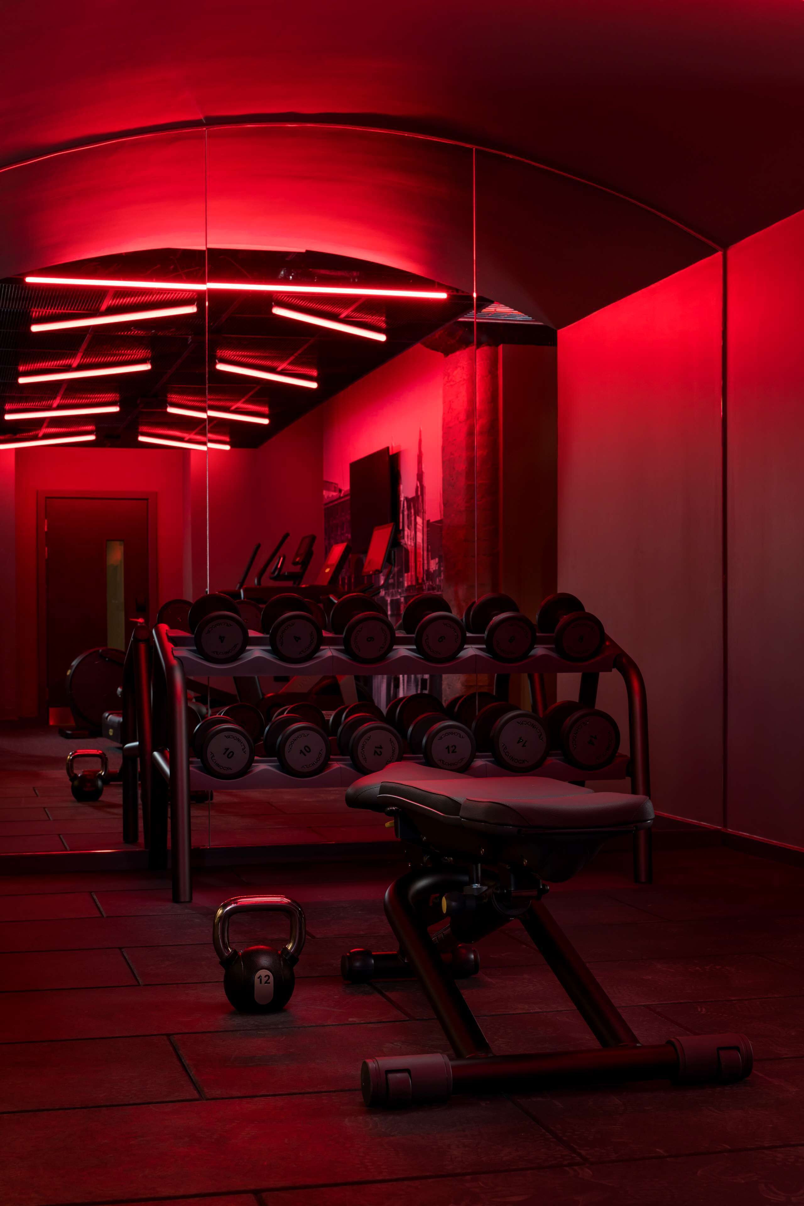 Un gimnasio con equipo de ejercicio y pesas.