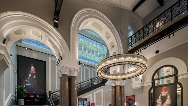 A grand lobby with a staircase, a reception desk, and a large chandelier. - Radisson RED Liverpool (Liverpool)