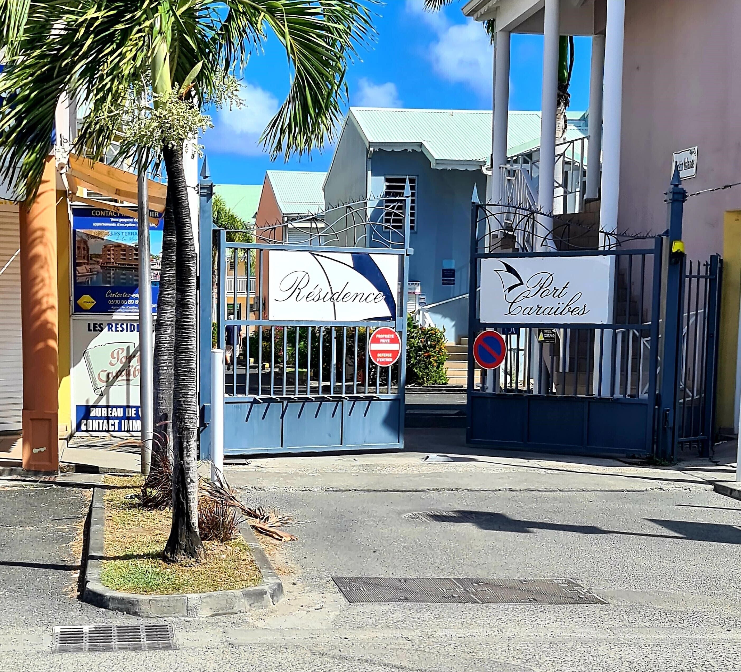 A gated entrance with signs reading "Residence" and "Port Cardibes."