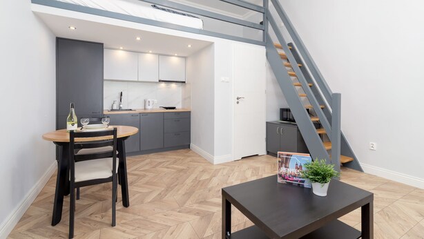 Un appartement moderne comprenant une cuisine, un coin repas et un escalier.