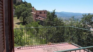 A balcony with a metal railing overlooking a hillside with buildings and trees. - Farmhouse Il Palazzetto with a panoramic view (Campello sul Clitunno)