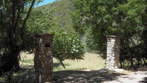 A stone gate in a forested area with a dirt path leading through it. - Farmhouse Il Palazzetto with a panoramic view (Campello sul Clitunno)