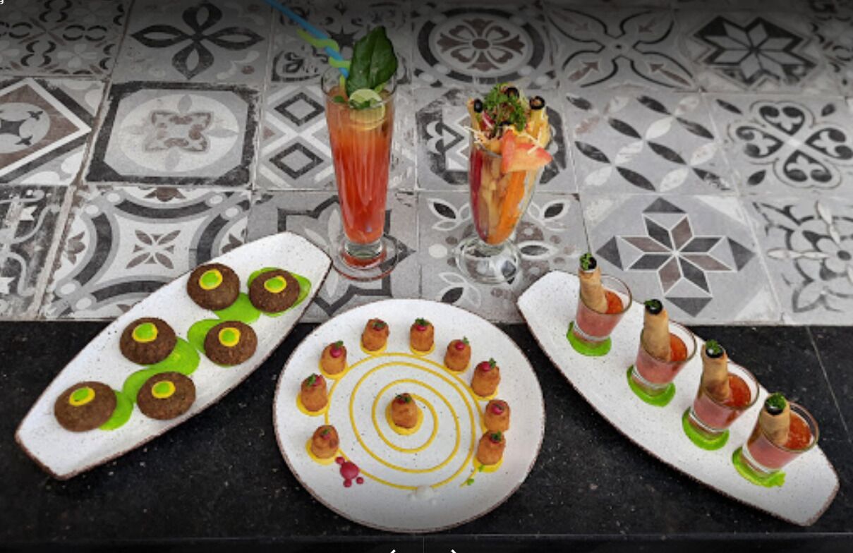 Una mesa con tres platos de aperitivos, cada uno con diferentes guarniciones y salsas.