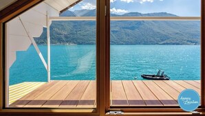 A deck with a view of a lake and mountains.