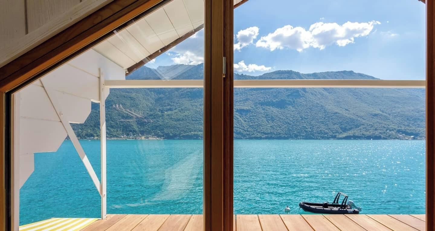 Une terrasse avec vue sur un lac et des montagnes.