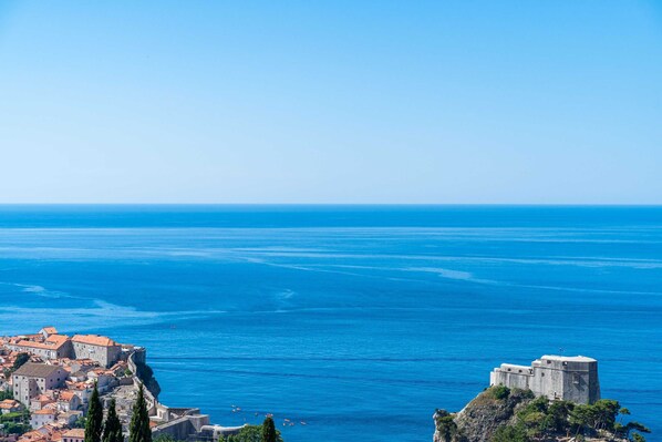 A coastal town with historic buildings and a prominent fort overlooking the sea.
