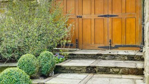 A stone staircase leading to a wooden gate with a metal latch. - Garden Stable: Cosy Stone Cottage with Parking (Alnmouth)