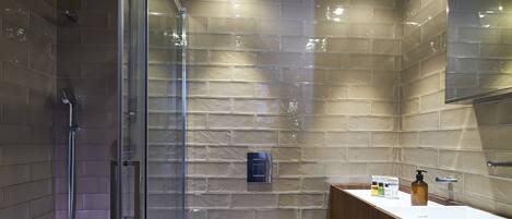 A modern bathroom with a glass-enclosed shower, a wooden vanity, and a large mirror.