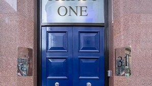 Een blauwe deur met het cijfer 31 en de tekst 'THIRTY ONE' erboven.