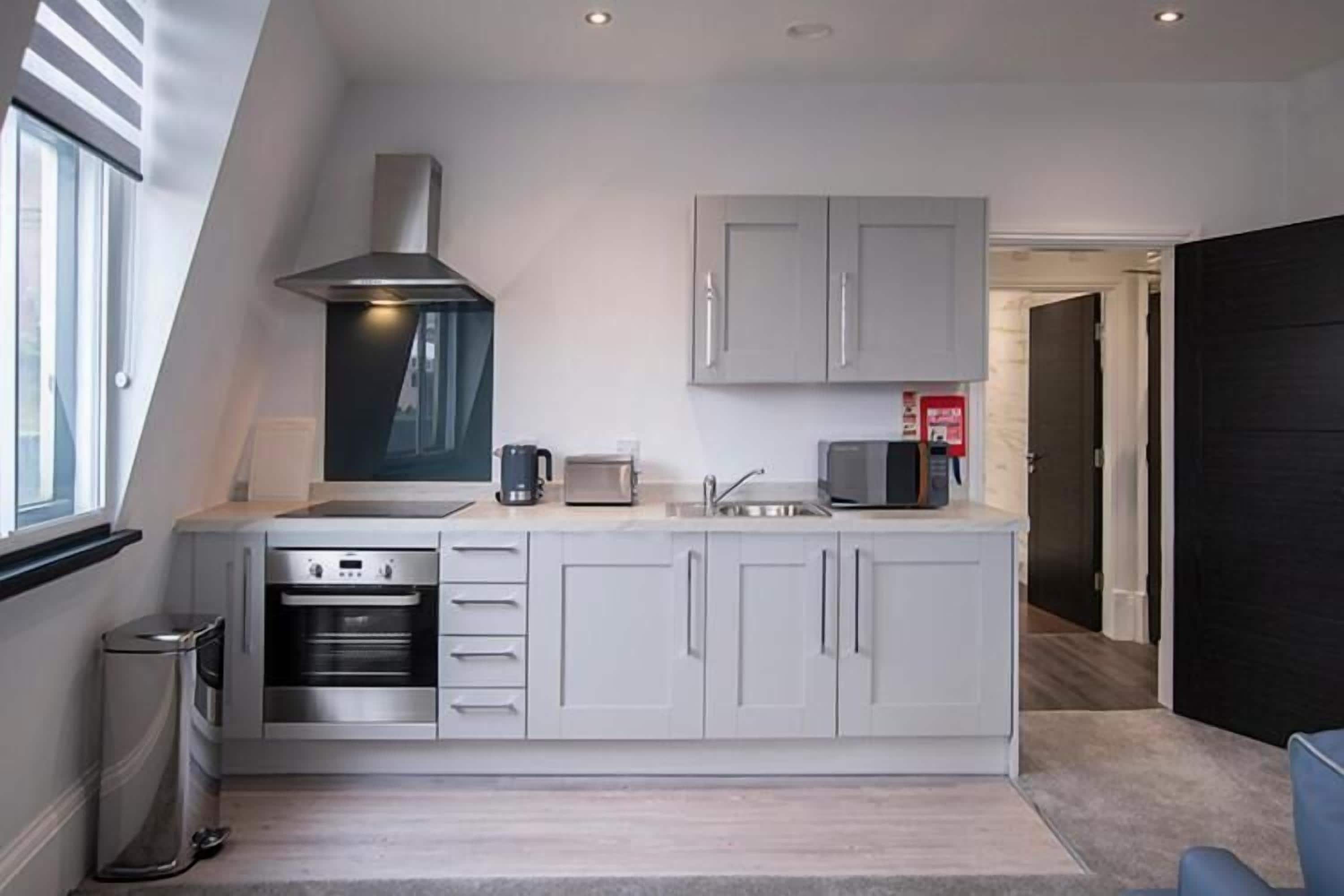 A modern kitchen with a built-in oven, a microwave, and a coffee maker.