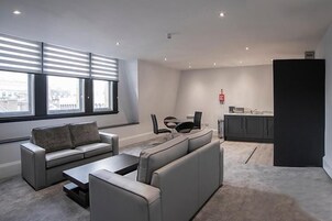 Una sala de estar moderna con sofá, mesa de centro y comedor.
