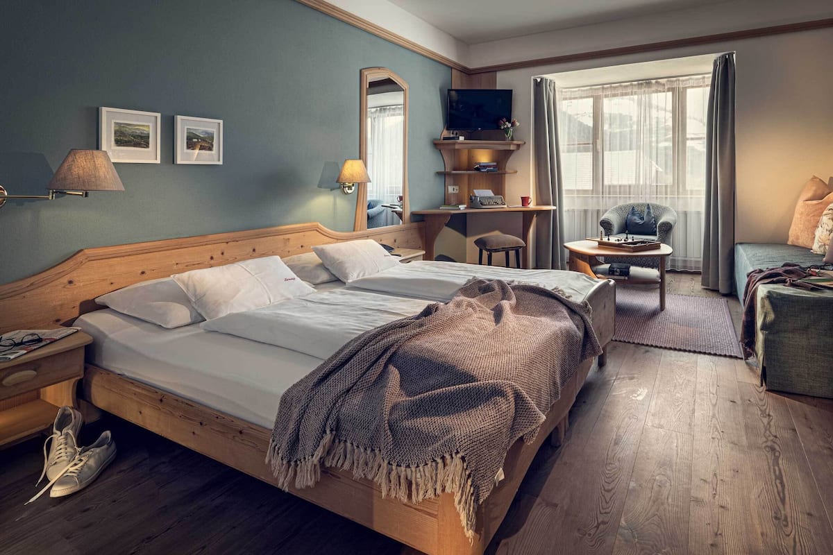 Een hotelkamer met een groot bed, een bureau, een stoel en een televisie.