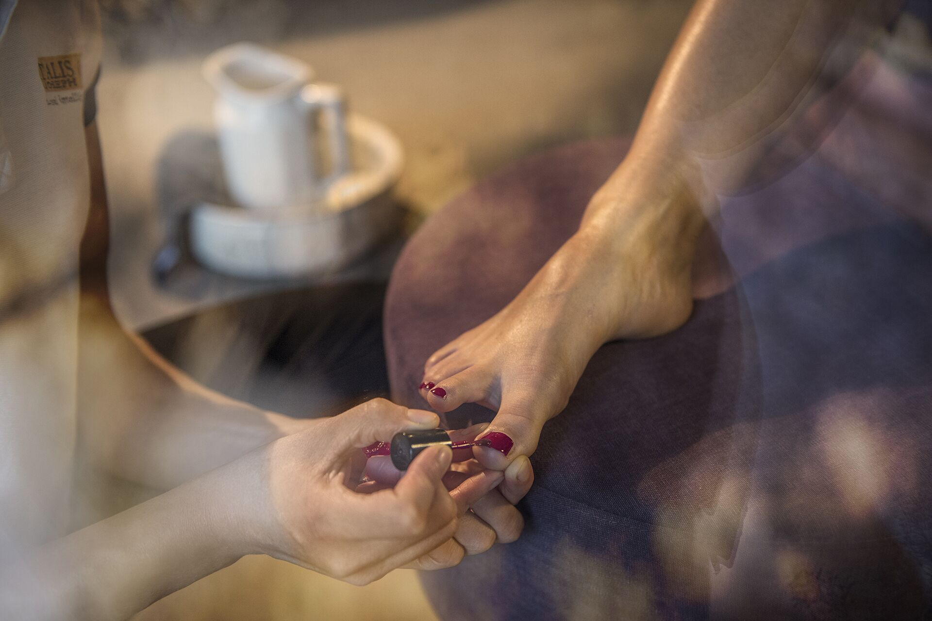 Un gros plan d’un pied sur lequel on applique du vernis à ongles.