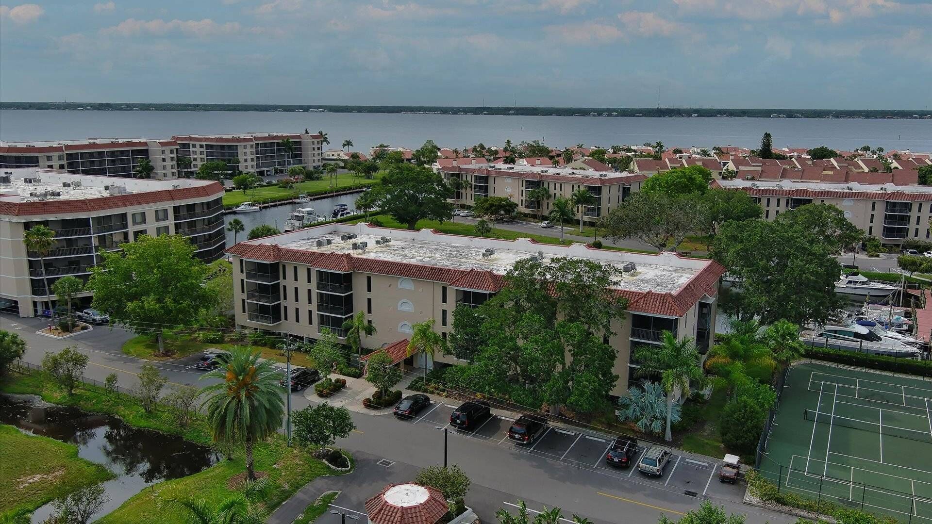 A residential area with apartment buildings, a marina, and a tennis court.