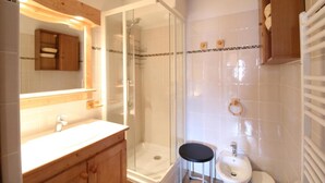 A bathroom with a glass-enclosed shower, a wooden vanity with a sink, and a mirror above the vanity. - 10m from resort center, 2nd floor, balcony, tv, ski locker, 42m², Aussois (Aussois)