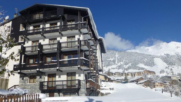 A multi-story hotel with balconies, set against a snowy mountain backdrop. - 10m from resort center, 2nd floor, balcony, tv, ski locker, 42m², Aussois (Aussois)