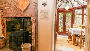 A rustic interior with a stone fireplace, a wooden heart decoration, and a sign that reads "Brave, Stronger, Brilliant." - The Lodge (Penrith)
