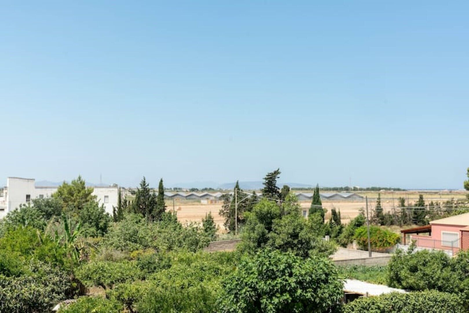 Un quartier résidentiel avec des maisons, des arbres et un ciel dégagé.