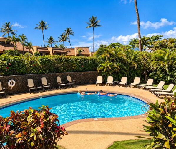 A swimming pool with lounge chairs and palm trees. - Prime Kihei 2BR Condo Breathtaking Panoramic Ocean Views Kamaole I Beach (Kihei)