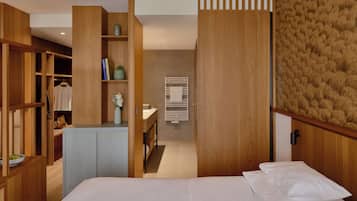 A modern bedroom with a bed, a wardrobe, and a vanity area.
