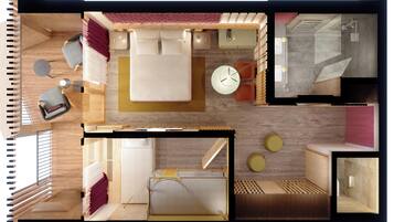 Grundriss eines Hotelzimmers mit Bett, Sitzbereich, Küchenzeile und Bad.