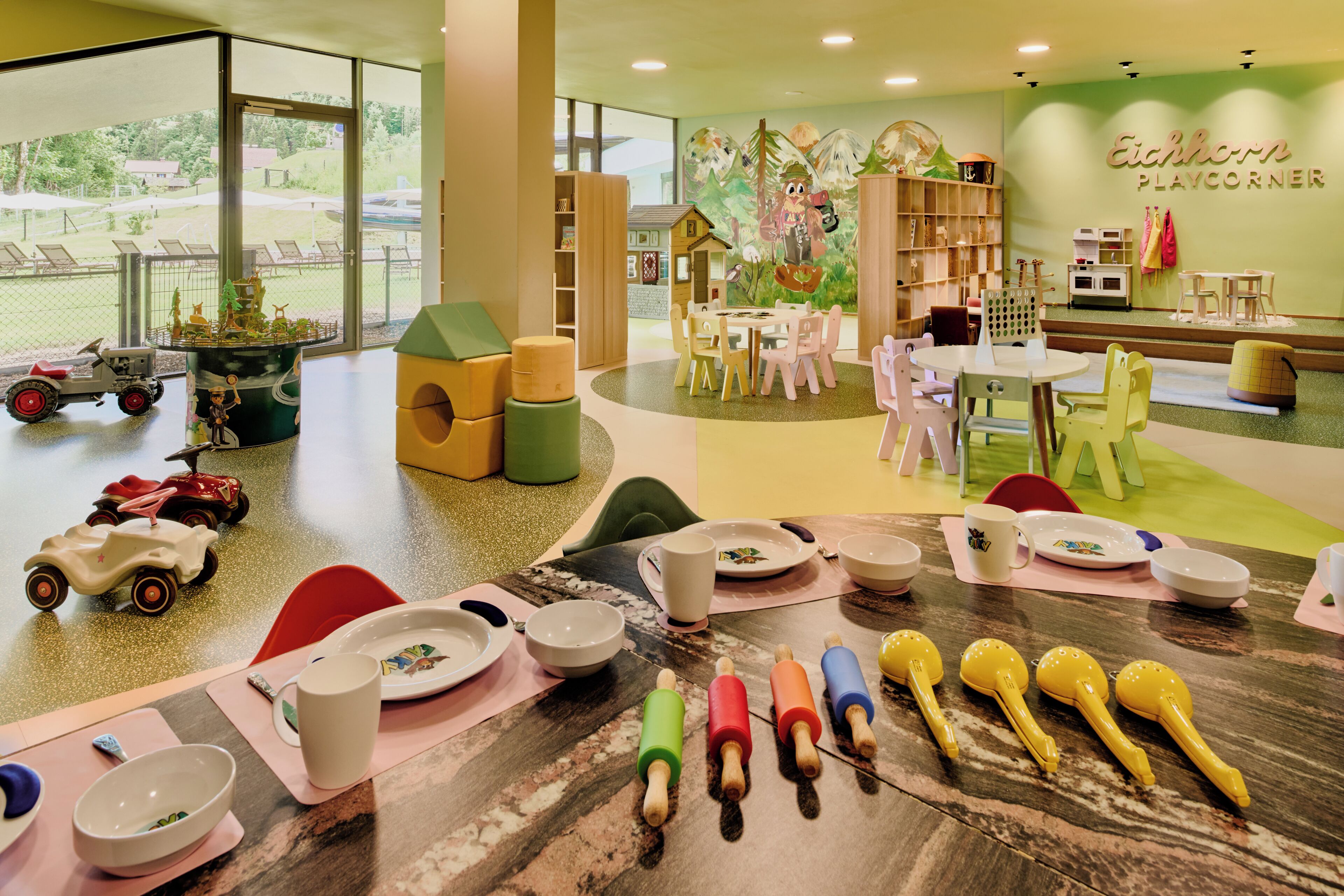 A children's play area with tables, chairs, and toys.
