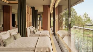 A modern hotel room with a balcony, large windows, and a sofa with multiple pillows.