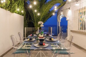 A glass-top dining table with clear chairs, set for a meal with plates, bowls, and a centerpiece. - Villa La Palmera with private pool and fantastic views (Salobreña)