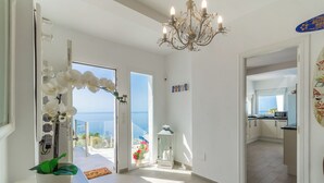 A bright, open-plan living area with a view of the sea, a chandelier, and a potted plant. - Villa La Palmera with private pool and fantastic views (Salobreña)