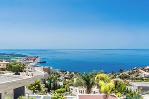A coastal town with a view of the sea, featuring modern buildings, greenery, and a clear sky. - Villa La Palmera with private pool and fantastic views (Salobreña)