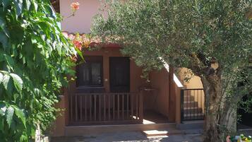 Stroll through the serene garden, surrounded by lush plants and a majestic olive tree, and enjoy the peaceful atmosphere on the balcony.